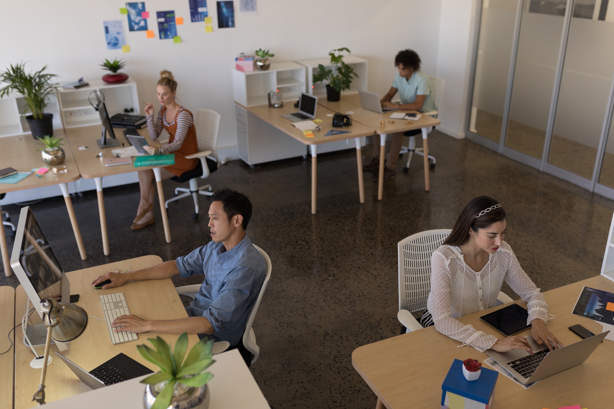 High angle view of diverse business people working at individual desks in modern office