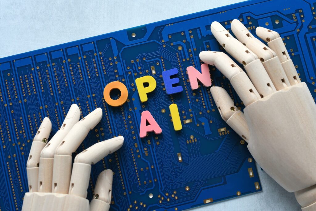 AI artificial intelligence concept - robot hand spelling out Open AI on blue computer motherboard