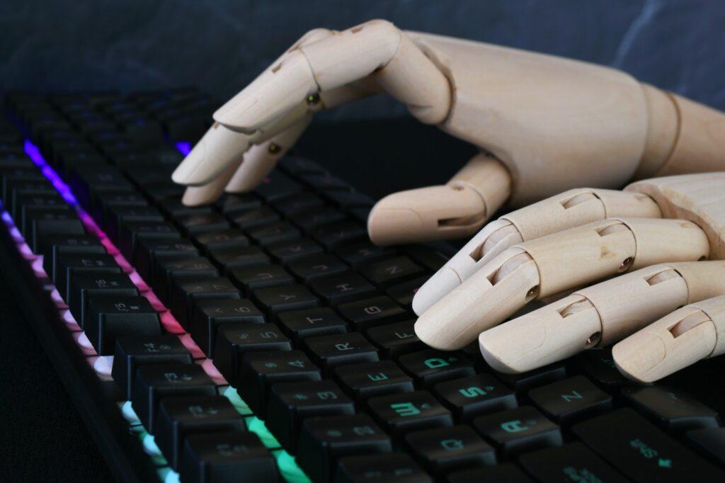 ai artificial intelligence concept robot hands typing on lit keyboard