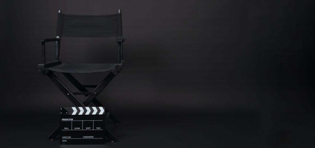 Black Director chair and Clapperboard ON black background.