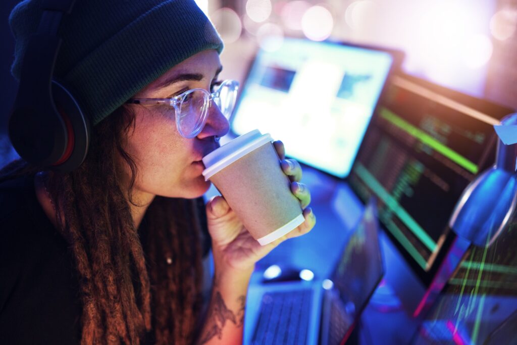 Computer, coffee or woman hacker in dark room at night for coding, phishing or researching blockcha