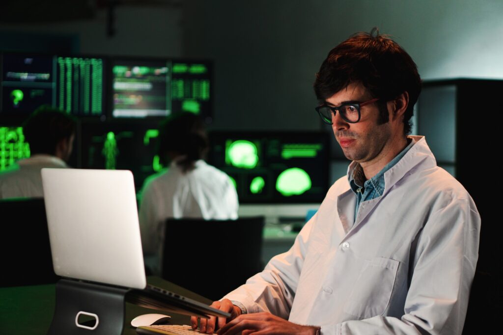 Serious biology scientific man working concentrated on pharmacy medical analysis with a laptop