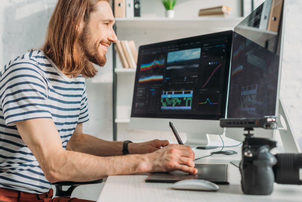 side view of happy filmmaker working in studio