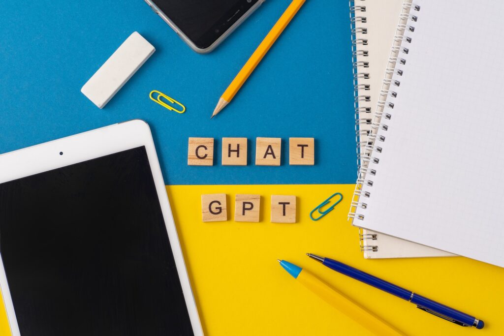 Work and study with the help of a chat bot. Words in wooden letters. Work table with open notebook.