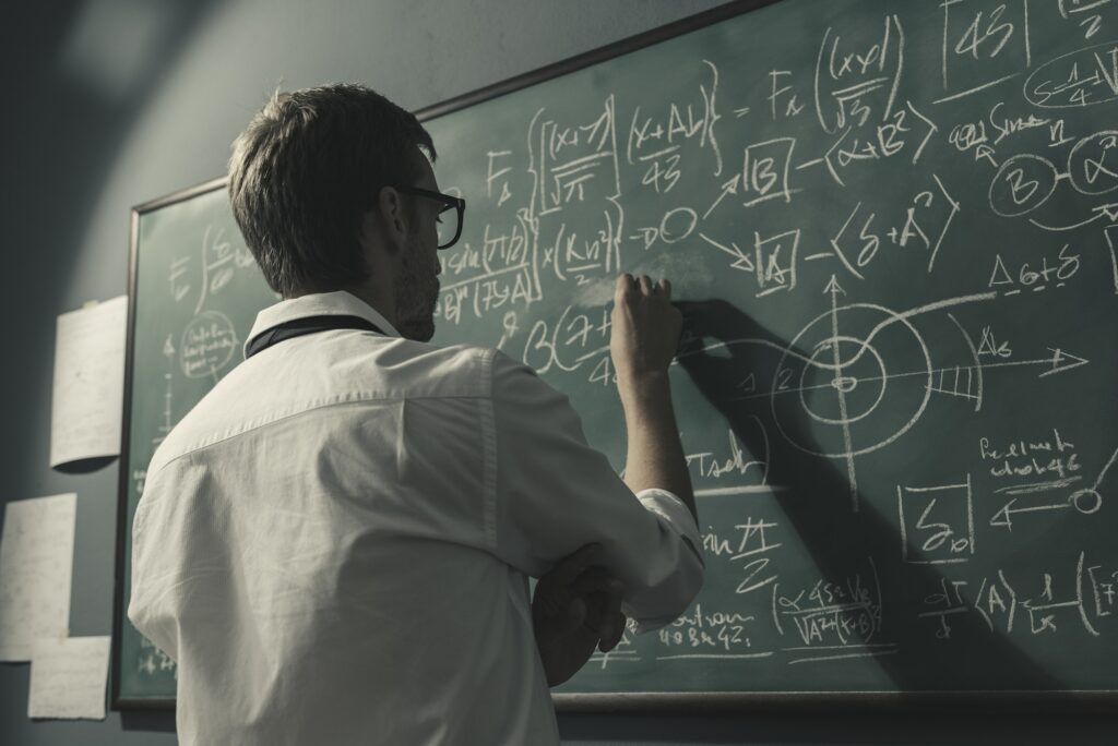 Young smart mathematician drawing on the chalkboard