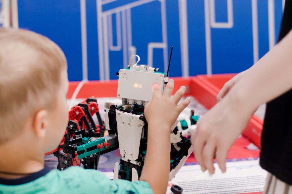 A boy looks at a robot at a robot exhibition.Artificial intelligence, the concept of the future.