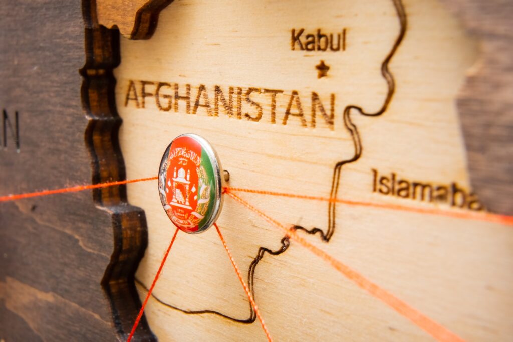 Afghanistan flag pins and red thread for traveling and planning trip.