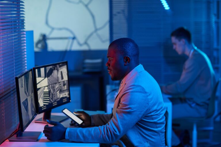 Black man looking at surveillance camera footage in security center office