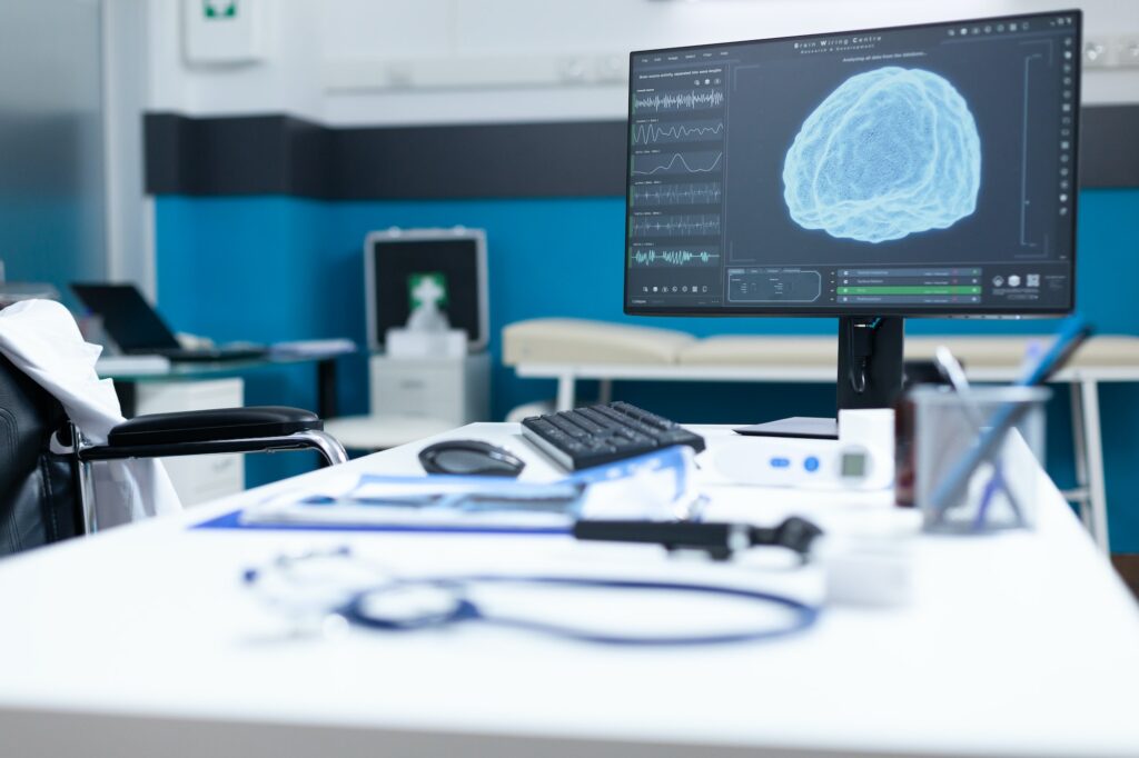 Computer standing on table having brain radiography on screen