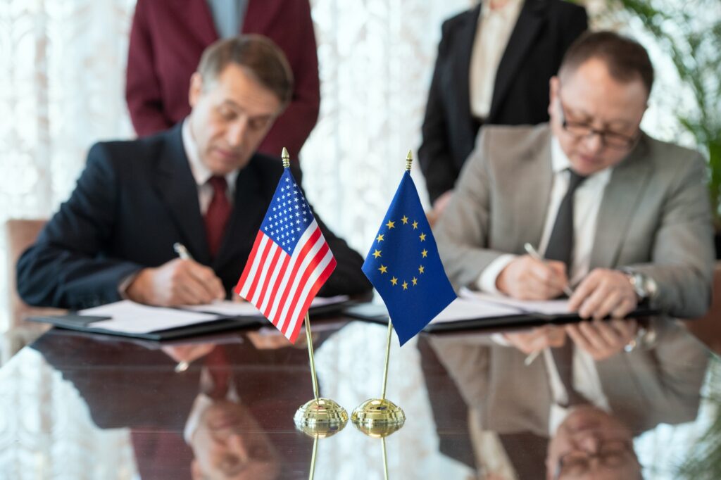 Flags of United States and European Union on table against two delegates