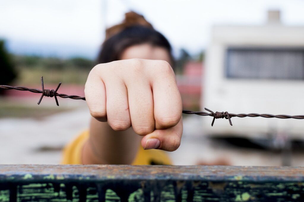 Hunger for freedom. The hands on the barbed wire.