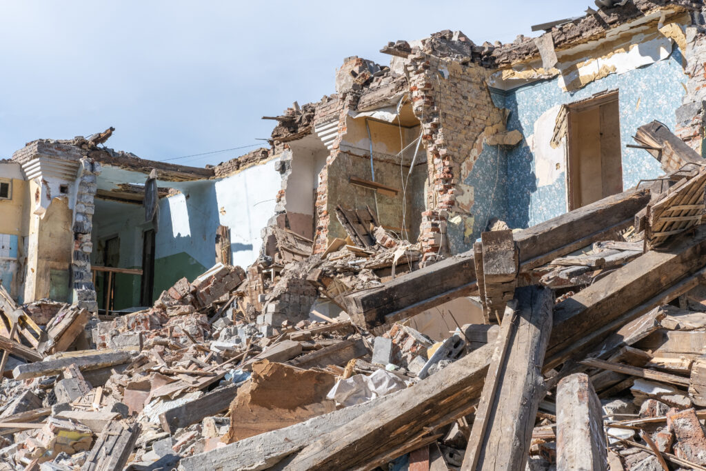 An abandoned house collapses. The house is destroyed. Cracks in wall of house. earthquakes