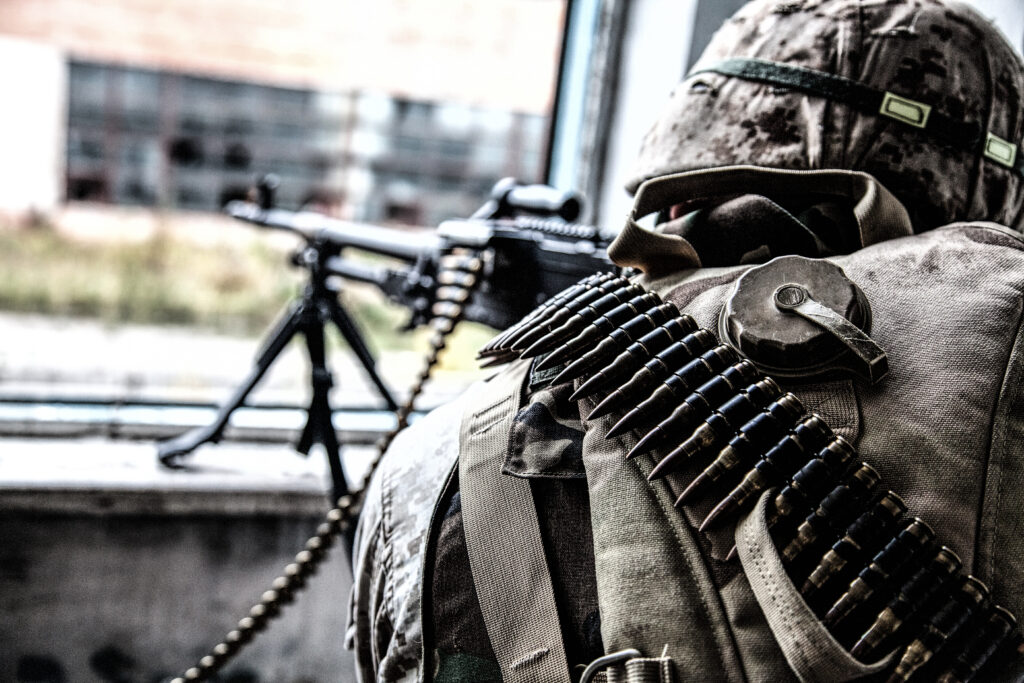 Commando soldier machine gunner firing from window