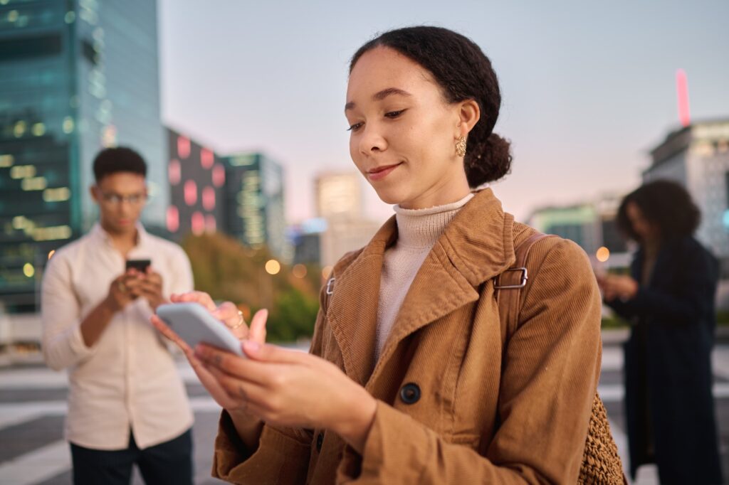 Phone, black woman and city with people using phone technology and 5g web on the street. Happy youn