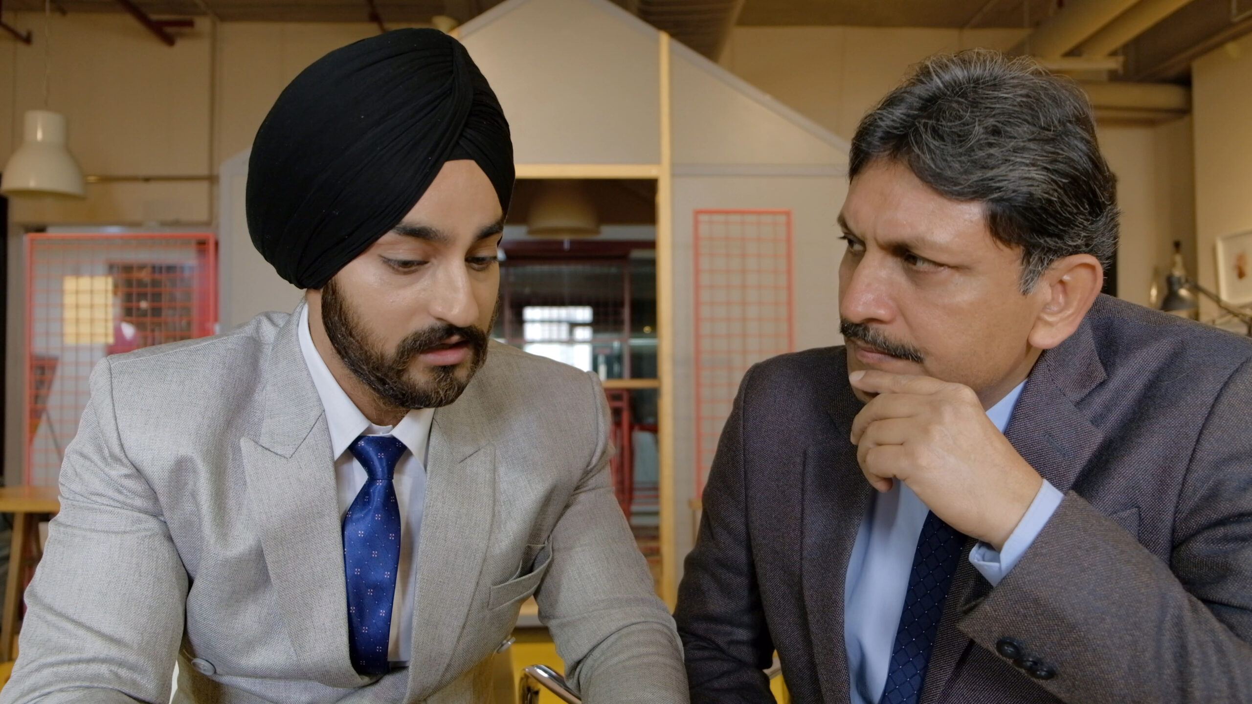 sikh businessman from india wearing the black turban having a meeting with his colleague