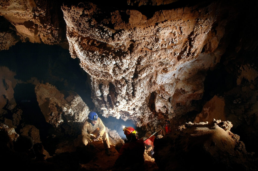 Spelunker admiring beautiful stalactites in a cave