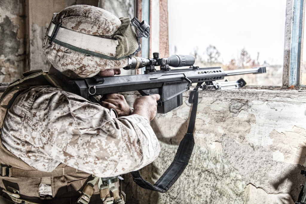 Army sniper shooting with large caliber rifle