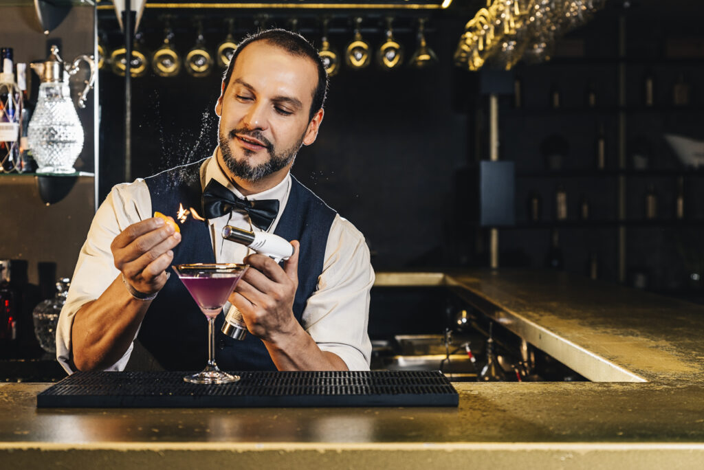 Barman is making cocktail at night club