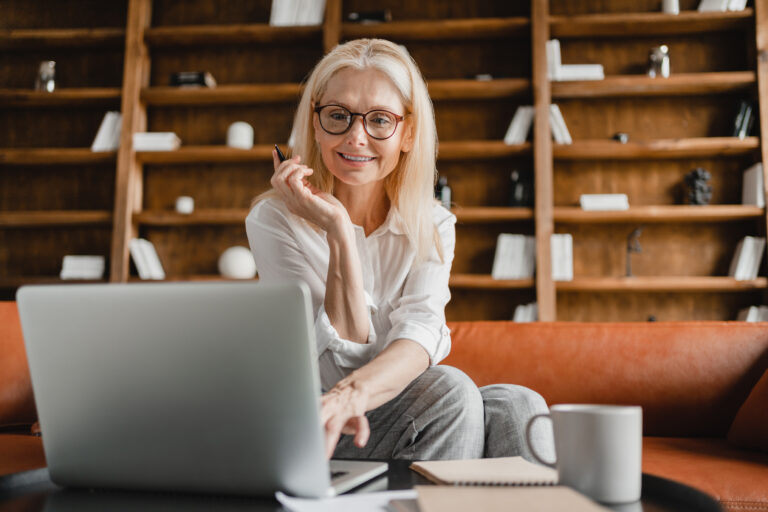 Businesswoman CEO freelancer teacher working on laptop in home office watching webinars, e-learning