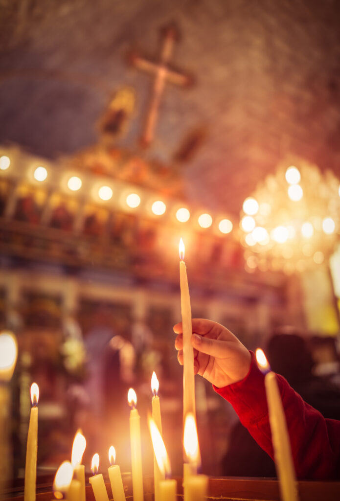 Child puts a candle in the church