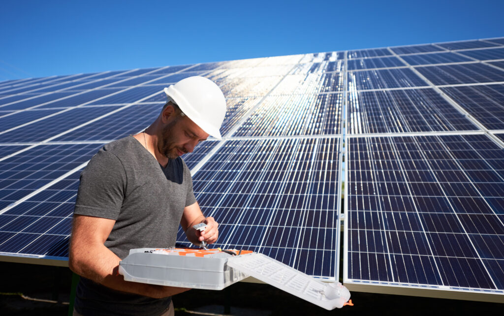 Concentrated architect keeping equipment standing near solar panels.