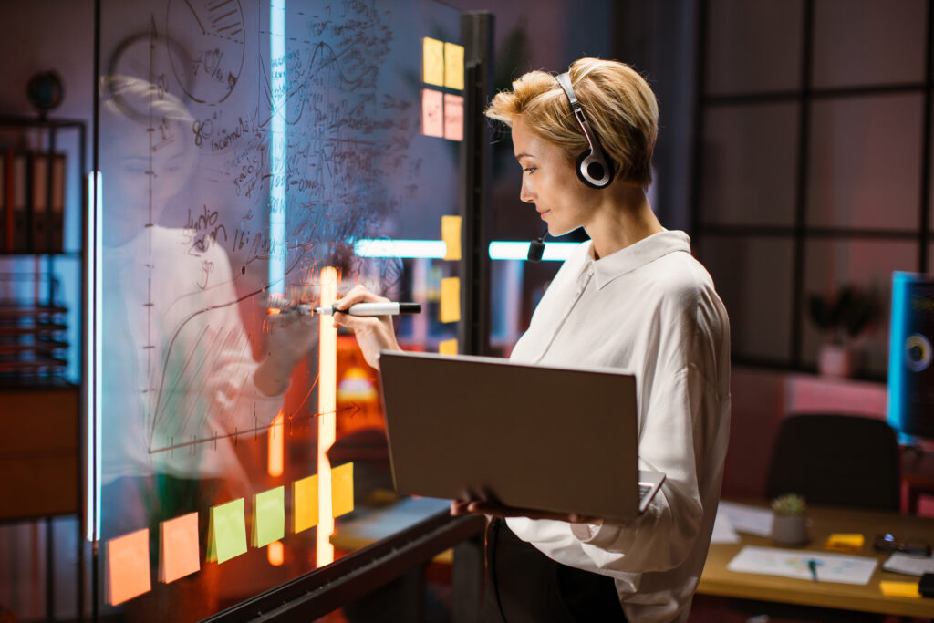 Female financial expert, ceo manager working near scrum kanban glass wall and writing ideas