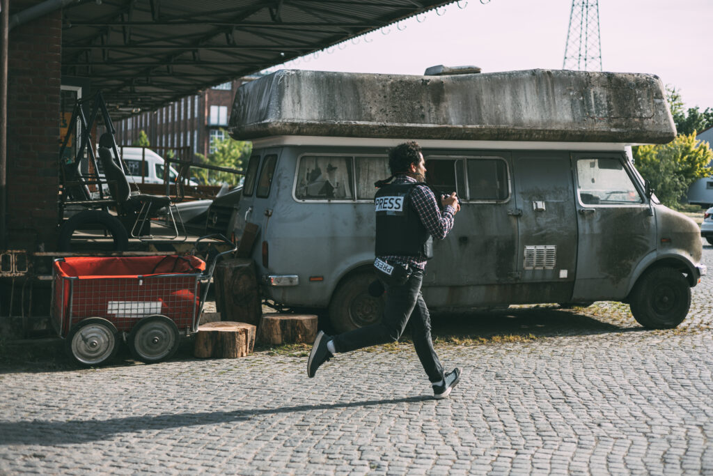 Photojournalist running with camera and helmet