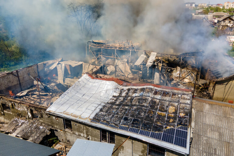 Ruined building on fire as example of rocket air strike result between Israel and Gaza