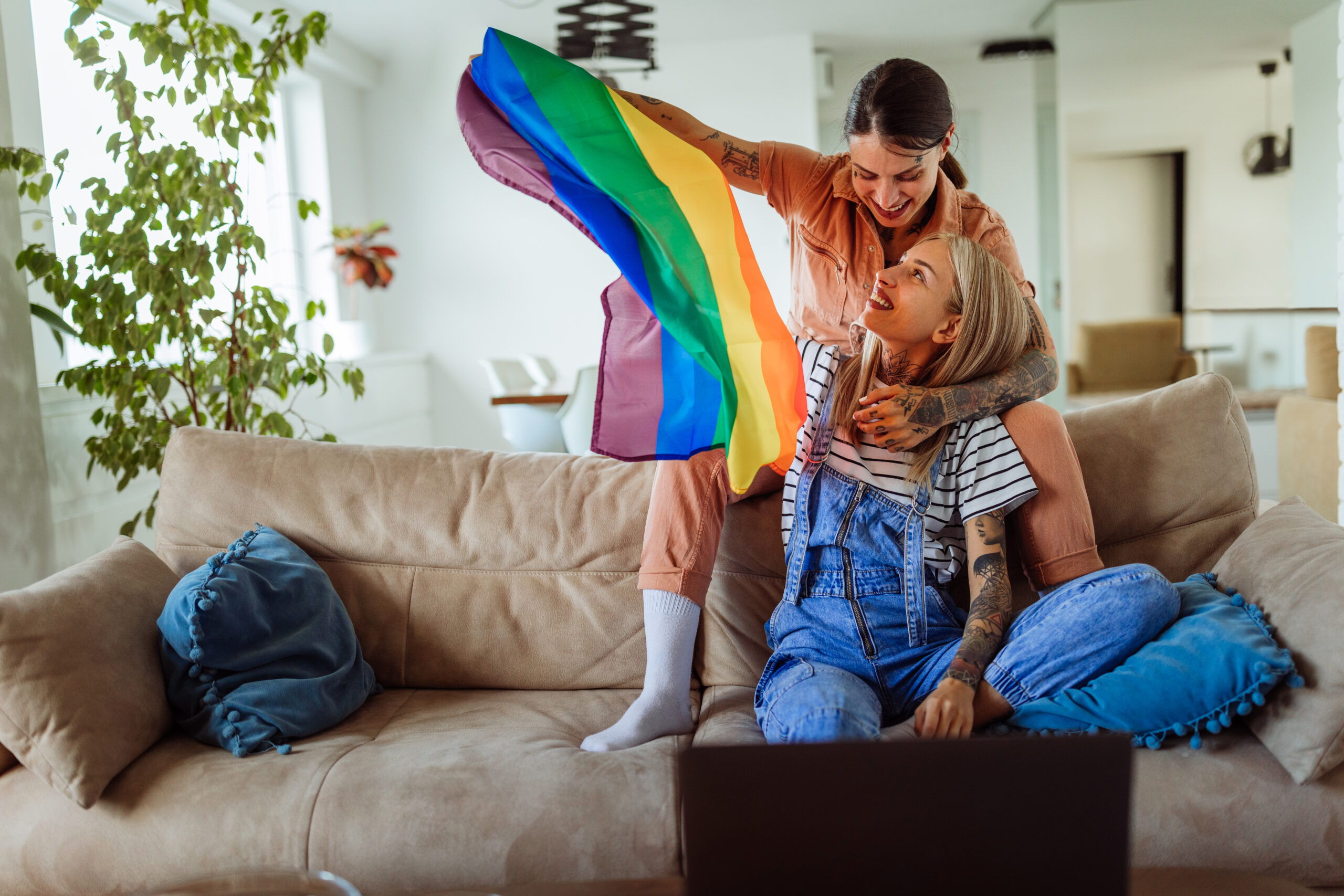 same sex couple with rainbow flag having video call at home