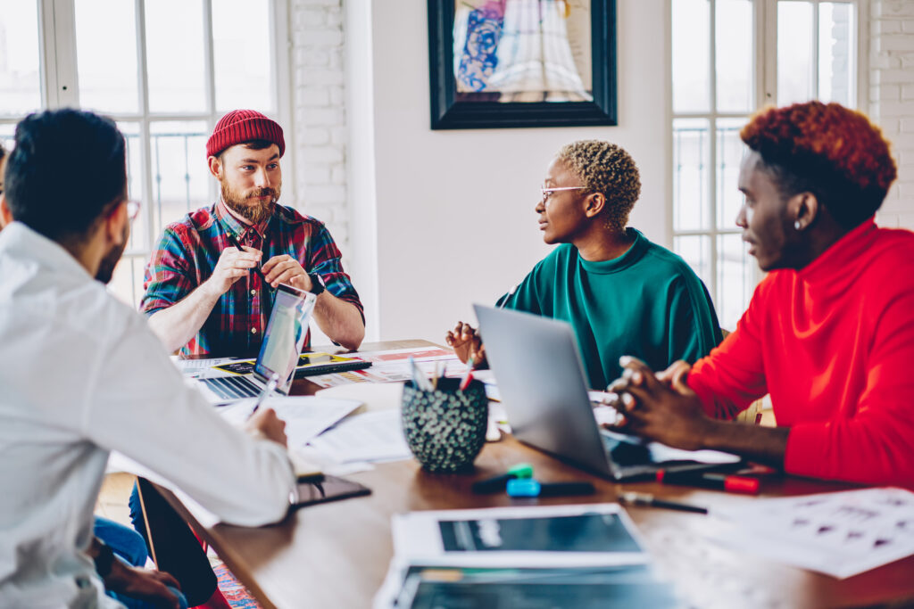 Skilled hipsters with laptop communicate about business project