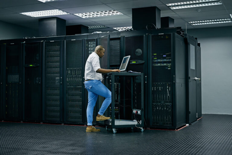 Skilled in all things IT. Shot of an IT technician using a computer while working in a data center.