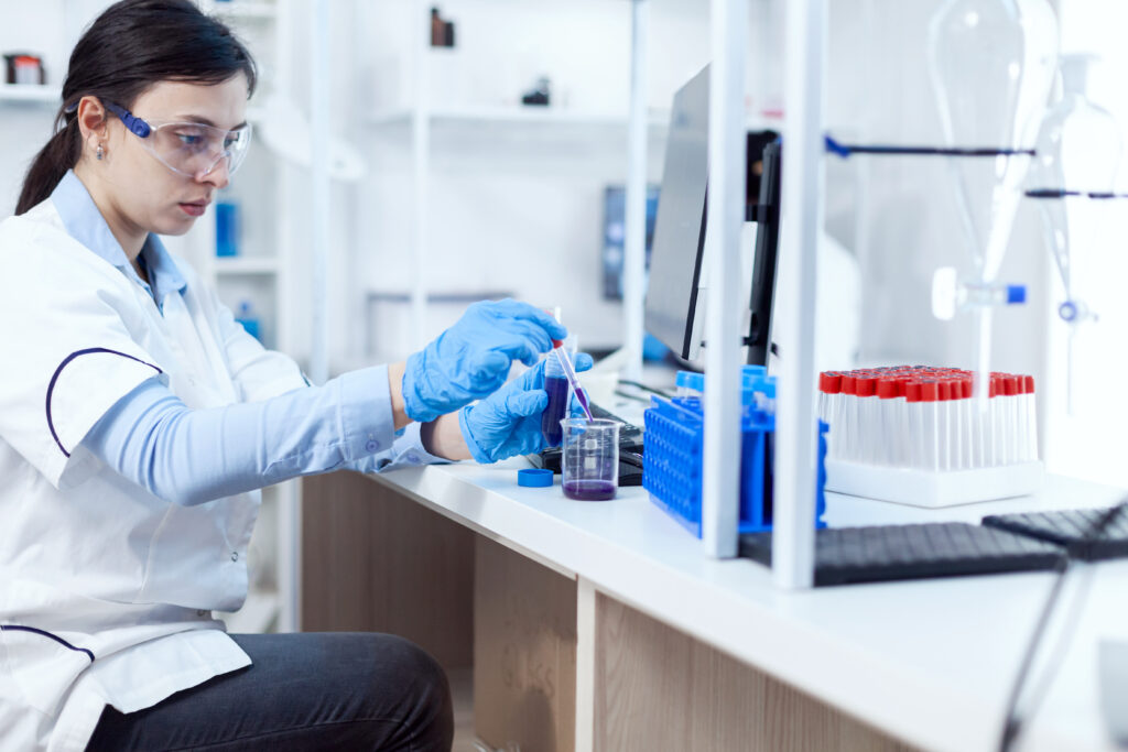 Woman scientist in healthcare industry taking sample from test tube