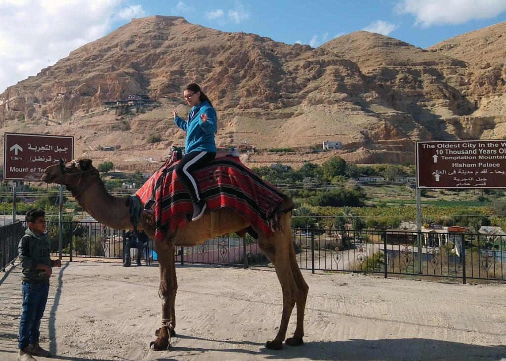 Young adult female riding a camel in the Gaza Strip of Syria. Camel ride in Gaza.