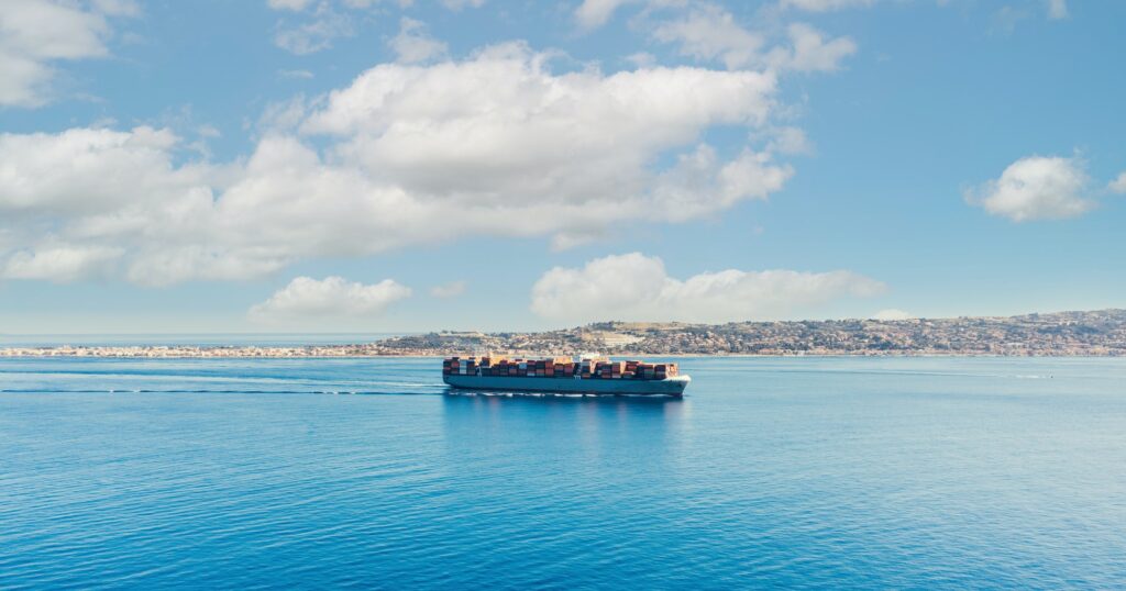 Container ship sails in the calm sea in the distance