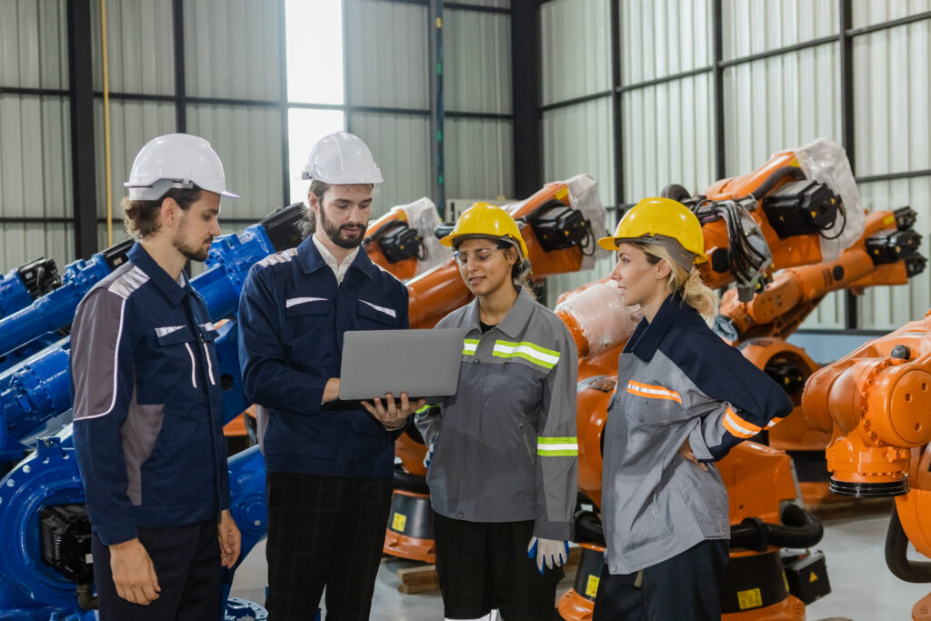 Engineers working robot assembly industry plant in factory, talking, meeting.