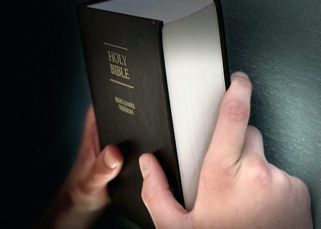 Human hands holding Bible. Spirituality, faith, religious beliefs. Freedom to worship. Christianity.