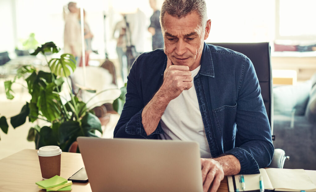 Mature businessman deep in thought at his office desk