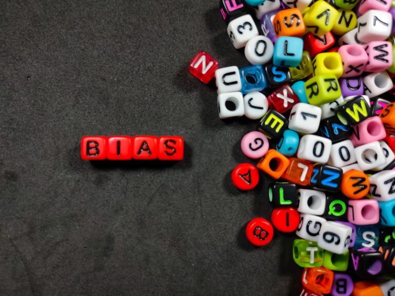 Selective focus.Colorful dice with color letter in word BIAS on black background.