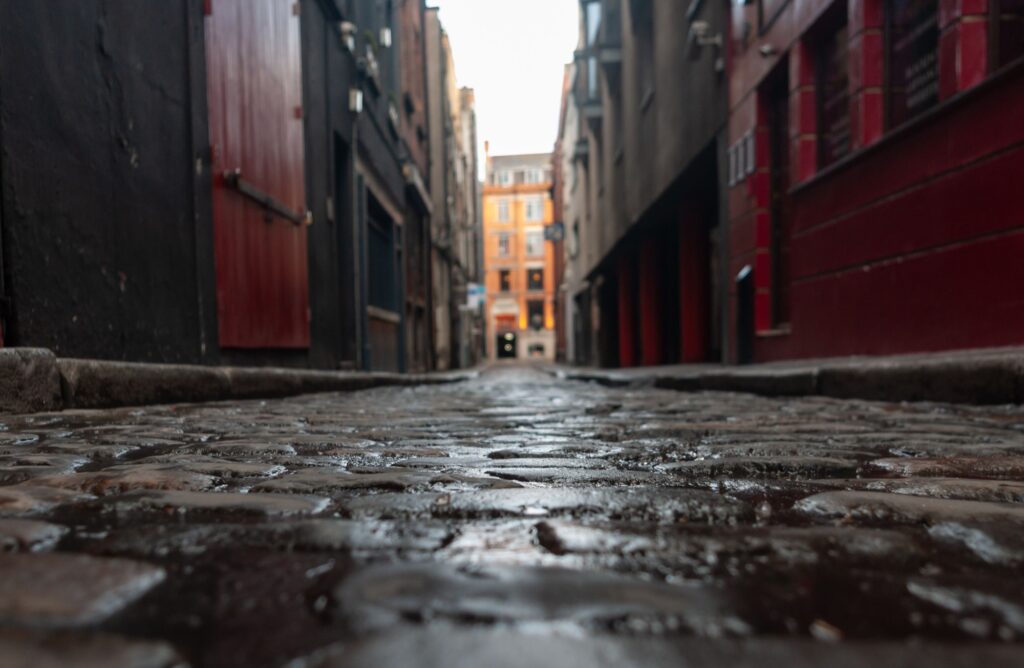 Selective focus of a paved street between old houses on a rainy day in Dublin, Ireland