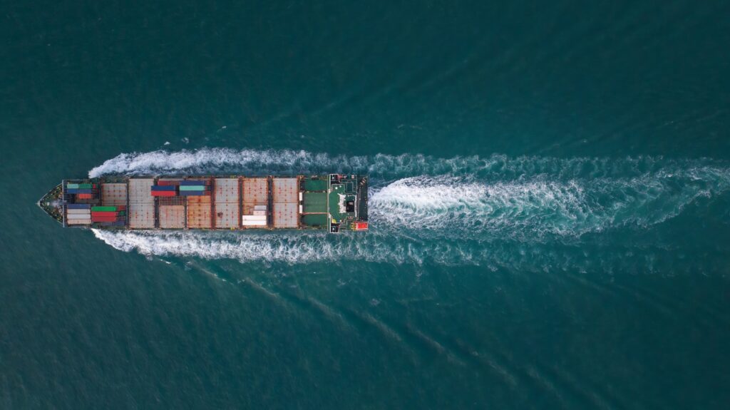 Top Ship view Cargo Container ship with contrail in the ocean ship carrying container and running