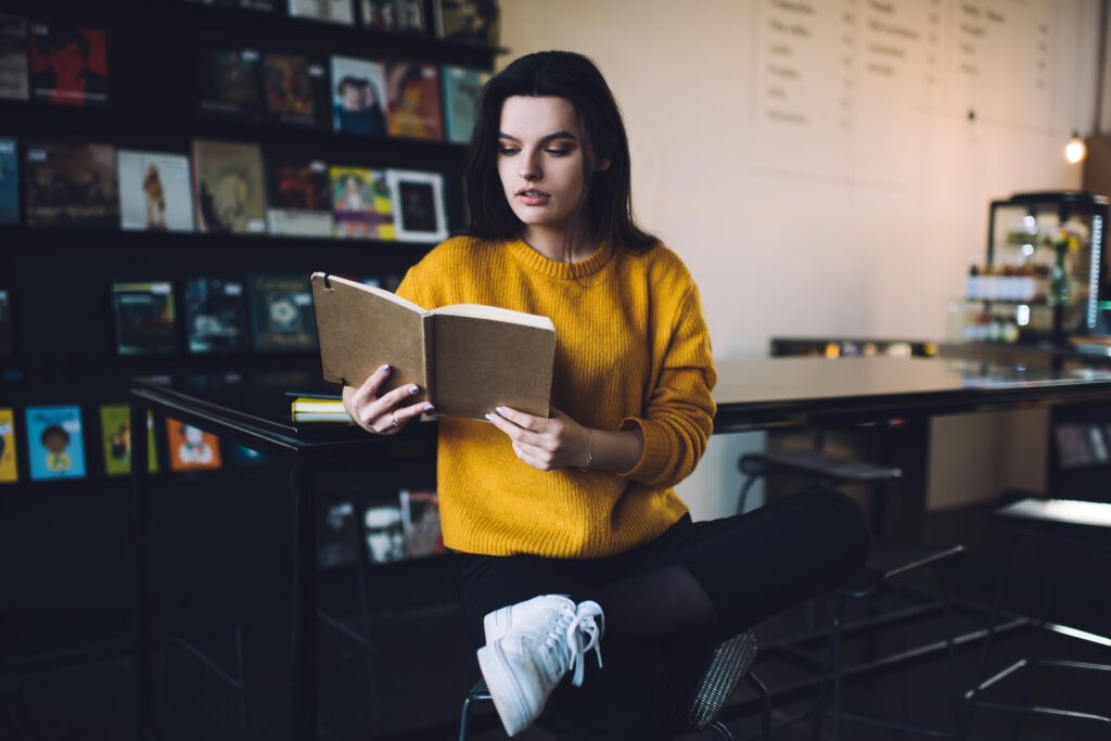 Young woman reading book in cafe