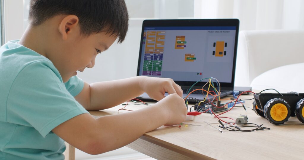 Asia home school young small kid happy smile self study online lesson excited make AI circuit toy