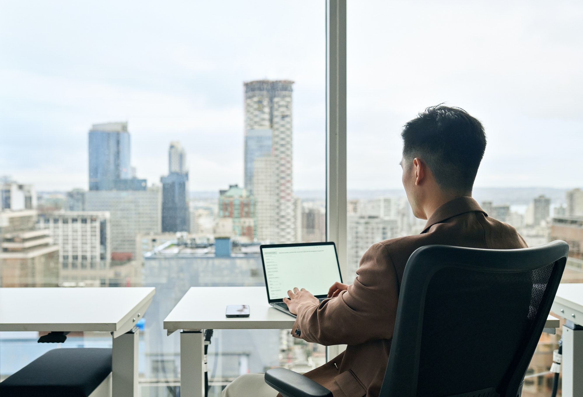 Business man working on laptop computer in office. White mock up screen