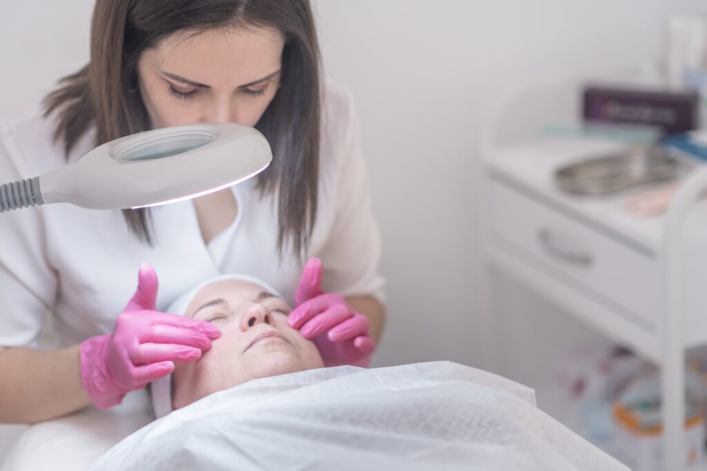 cosmetology guiding client towards healthier skin, consulting in beauty salon, examining skin