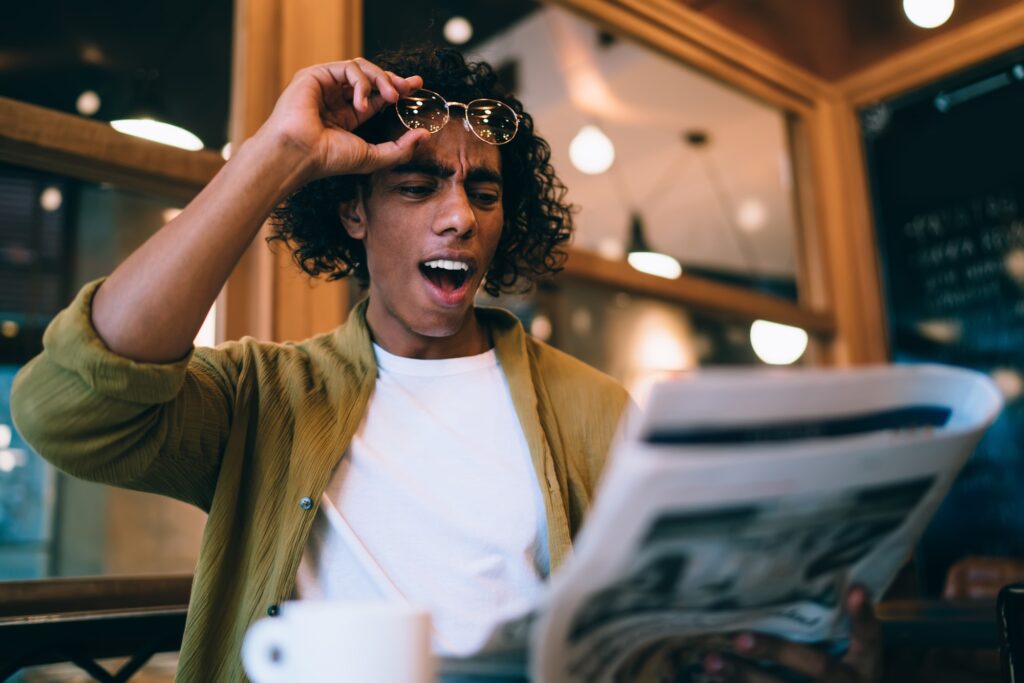 expressive male 20s shocked with financial economical information about business on leisure