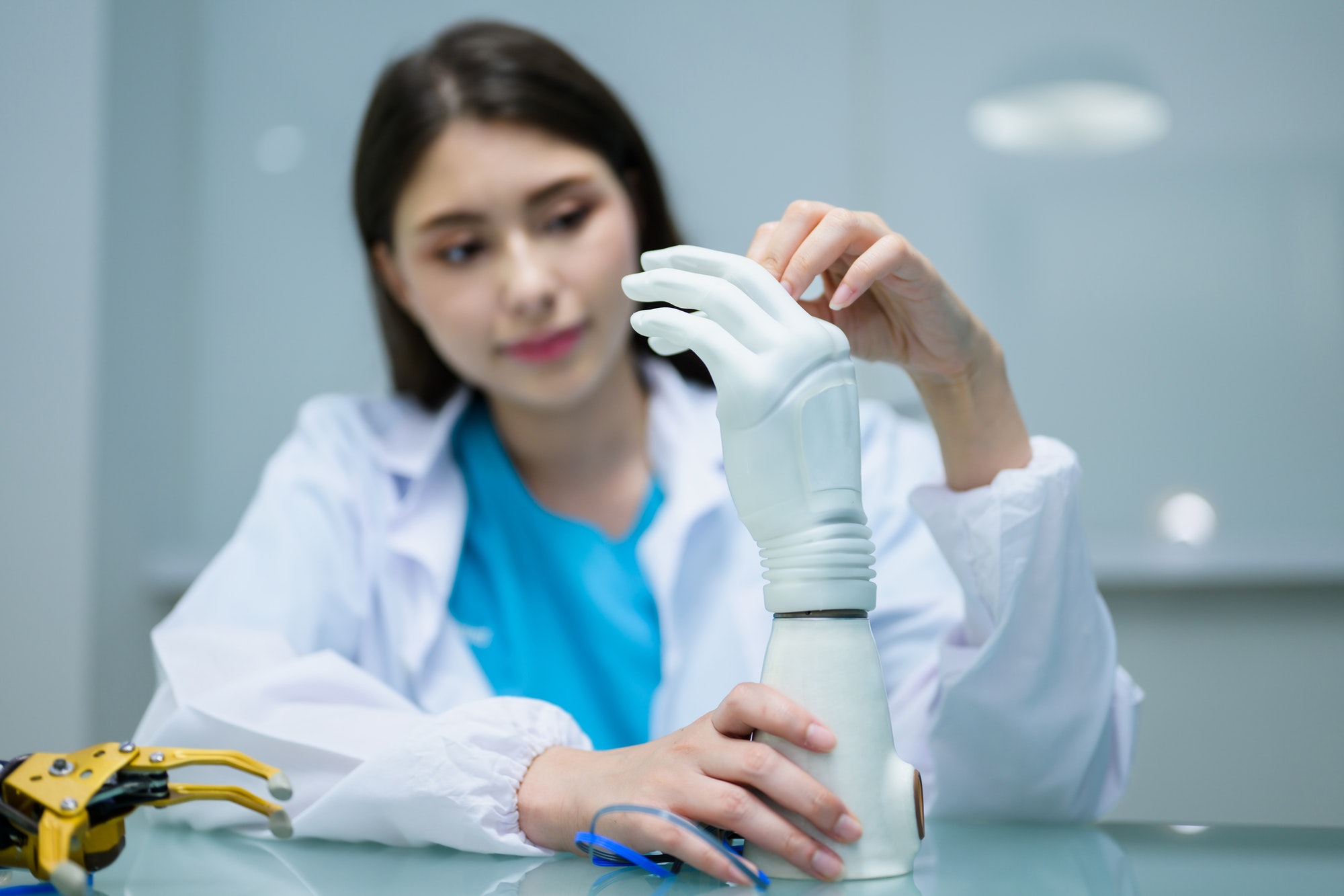 Female technician checking and controlling artificial prosthetic hand