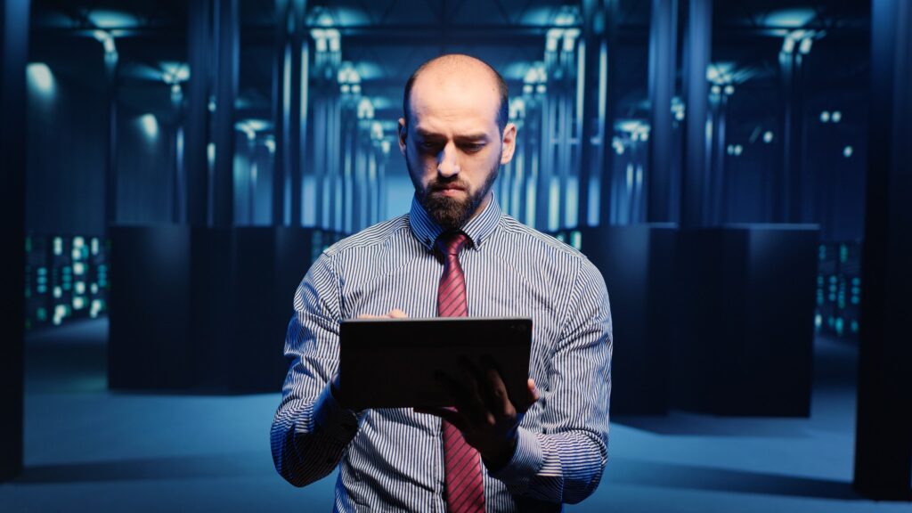 Male infrastructure specialist using tablet for hardware