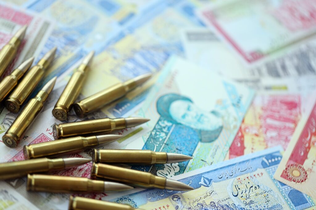 Many bullets and iranian rials money bills close up. Concept of terrorism funding