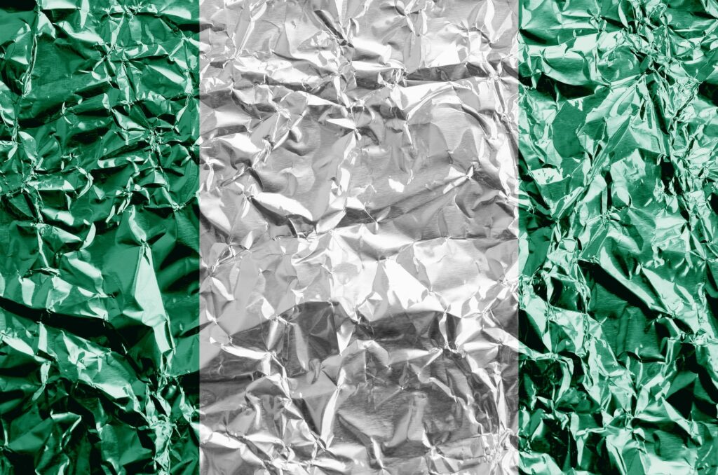 Nigeria flag depicted in paint colors on shiny crumpled aluminium foil close up