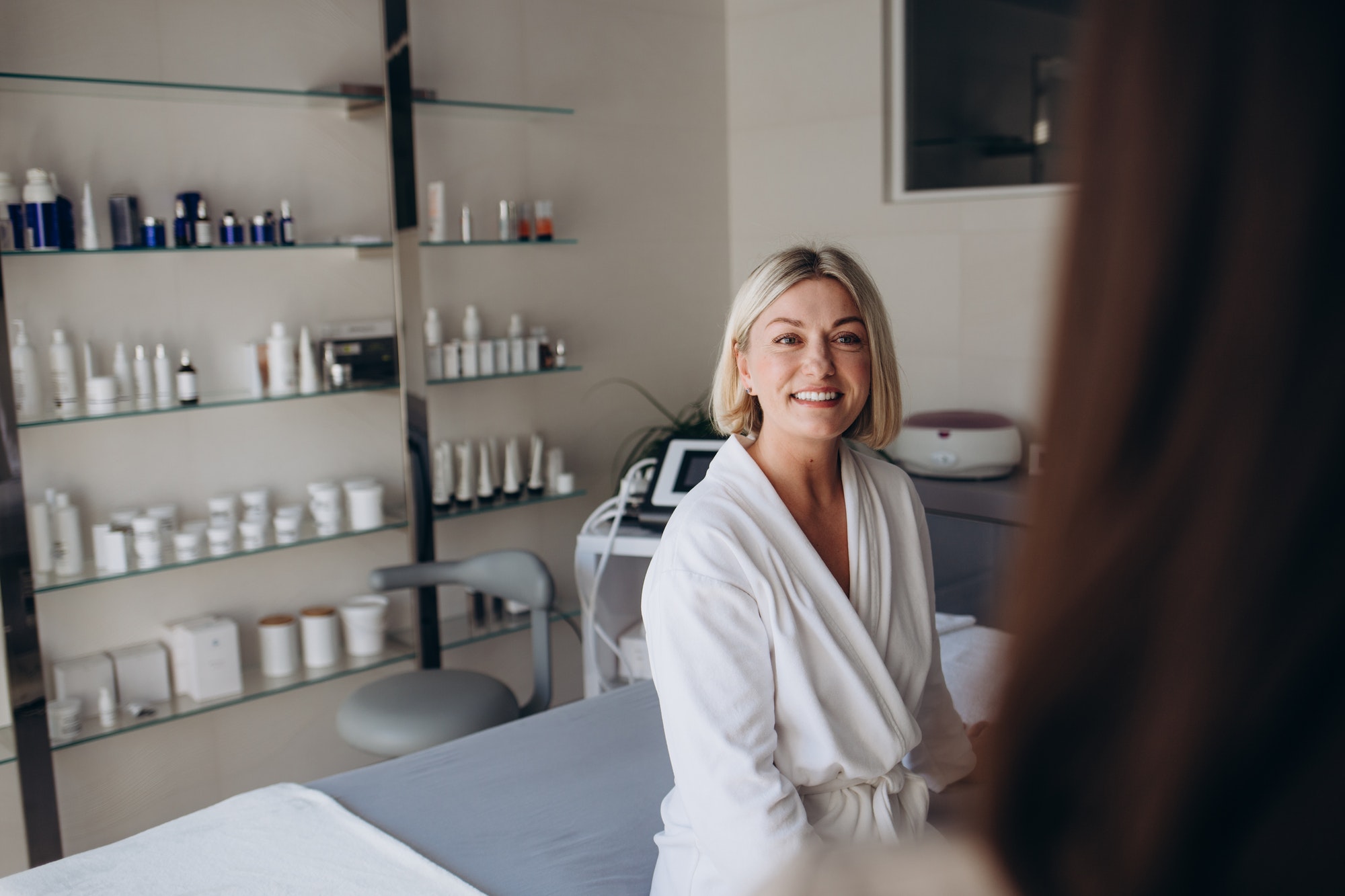 portrait of a female client in a white coat at a beautician